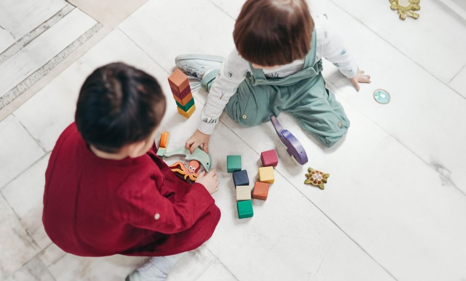 Two children playing with toys on the floor